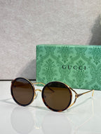 Round eyeglasses with gold metal frames and dark brown tinted lenses