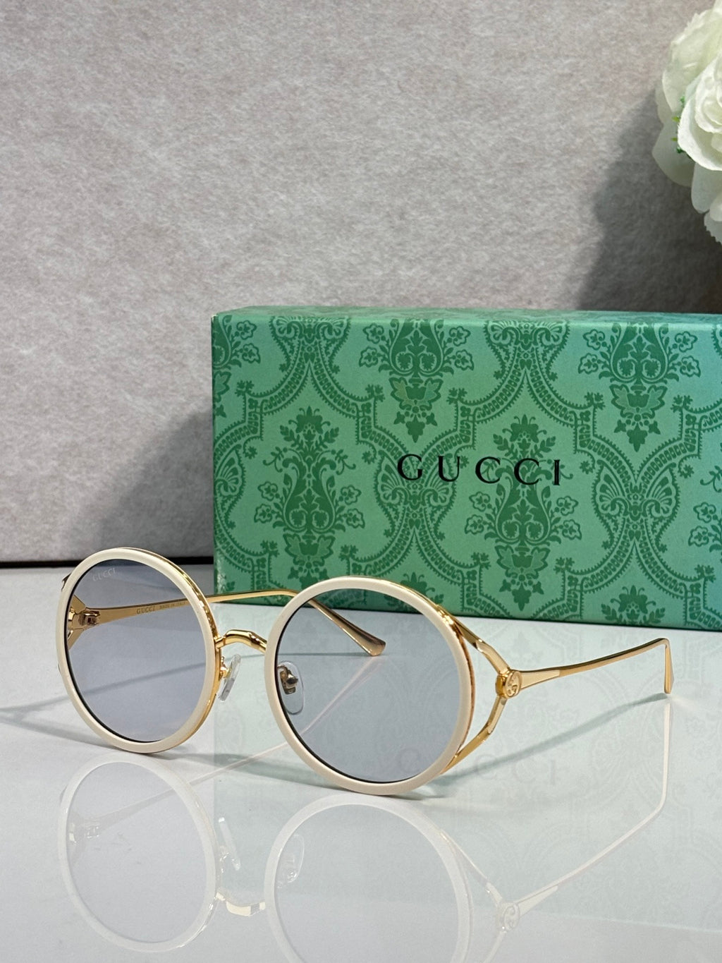 Gucci round eyeglasses with gold metal frames and light blue tinted lenses
