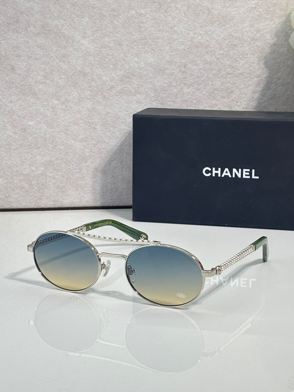 Round sunglasses with silver frame and light tinted lenses, beaded temple detail.