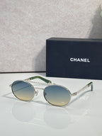Round sunglasses with silver frame and light tinted lenses, beaded temple detail.