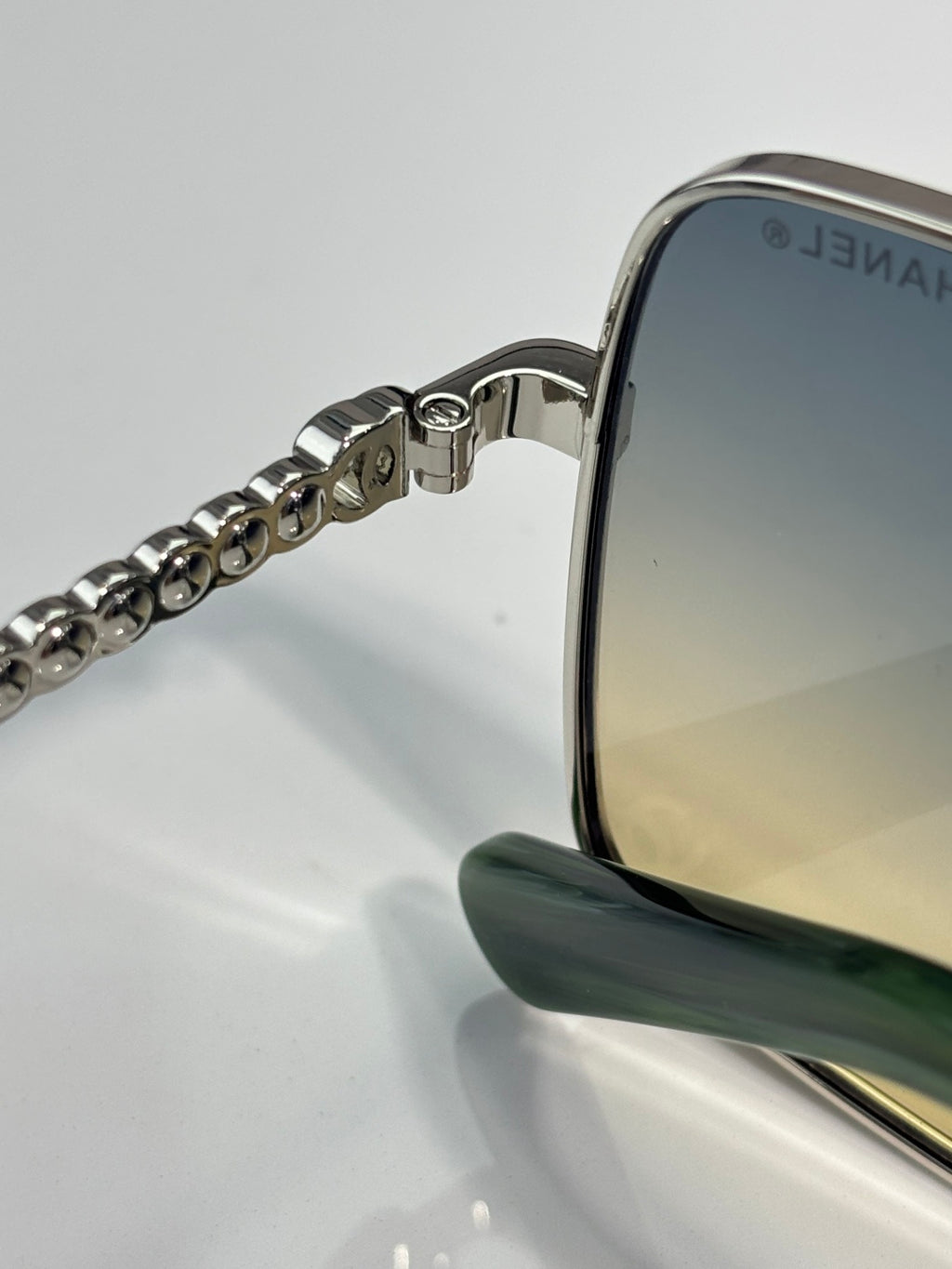 CHANEL sunglasses side arm close-up with silver chain detail