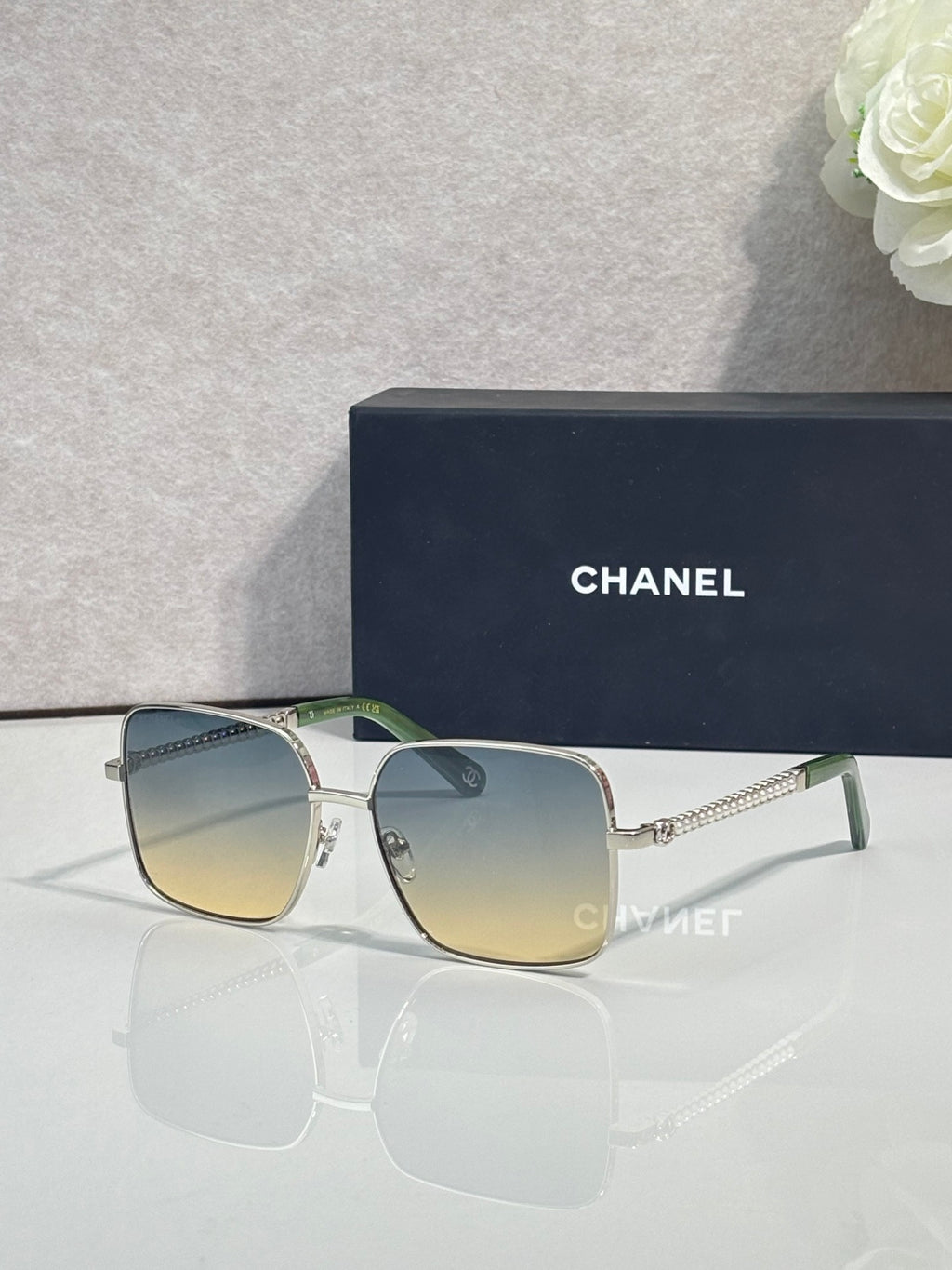 CHANEL square sunglasses with gold frames and pale blue lenses