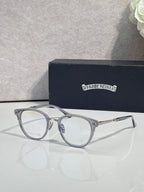 Silver round eyeglasses with clear lenses and decorative hinges