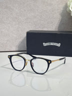 Navy round eyeglasses with gold temple tips and clear lenses