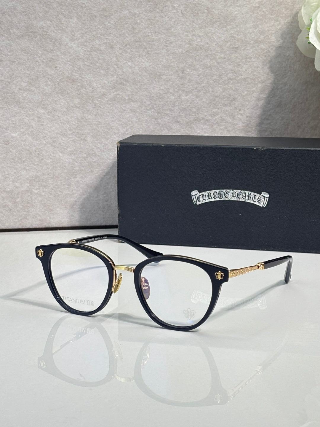 Navy round eyeglasses with gold temple tips and clear lenses
