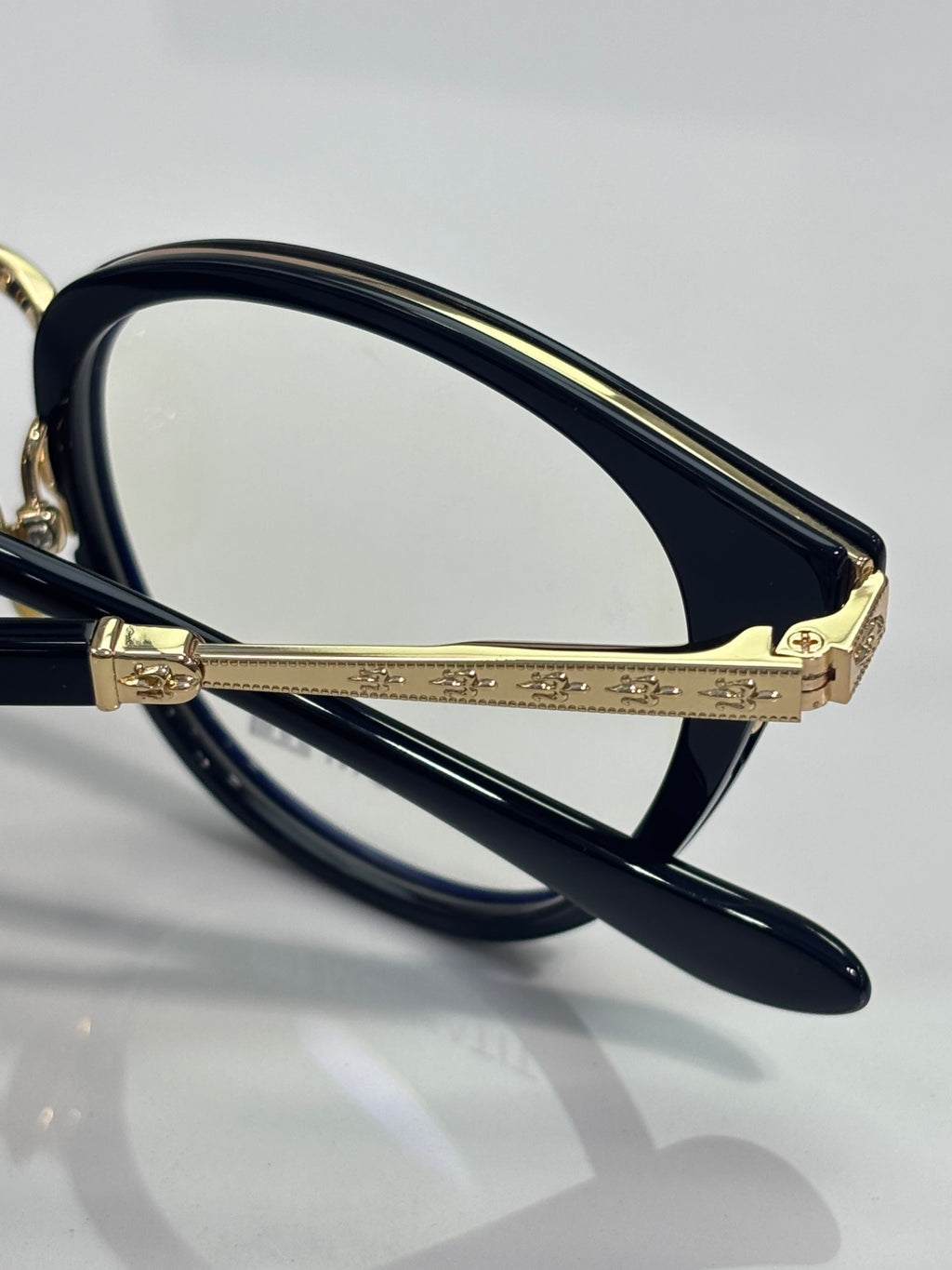 Navy eyeglasses with gold decorative bridge and clear lenses