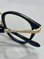 Navy eyeglasses with gold decorative bridge and clear lenses