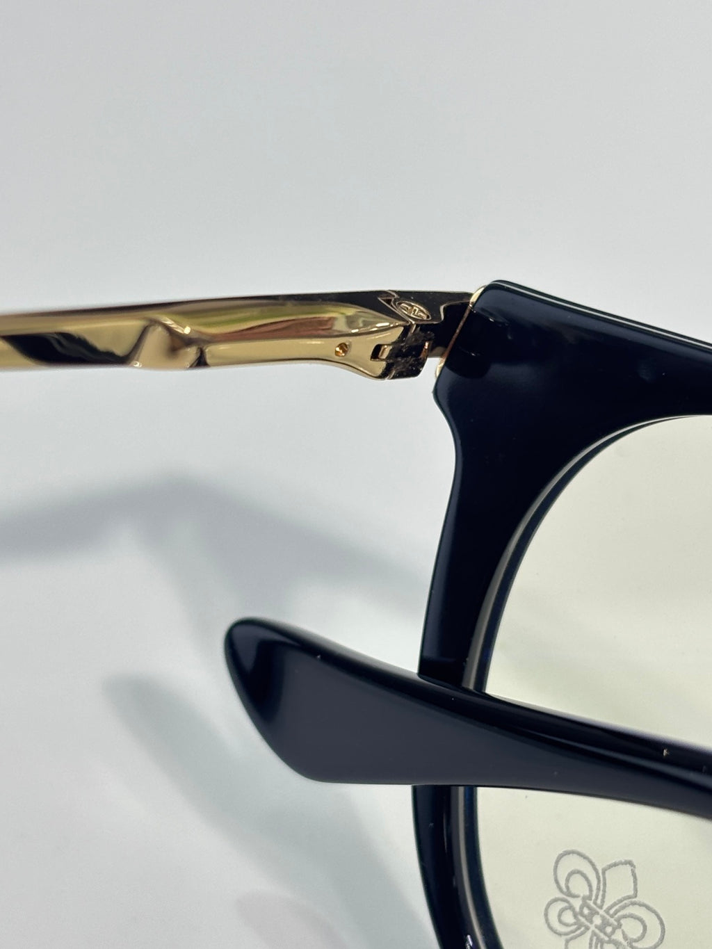 Navy eyeglass arm with gold hinge detail and clear lens