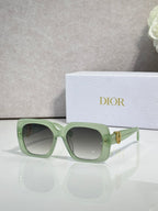 Dior sunglasses with light green frames and gray gradient lenses, gold logo hinge detail
