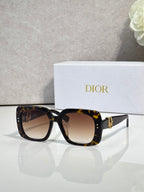 Dior sunglasses with tortoiseshell frames and brown gradient lenses, gold logo detail