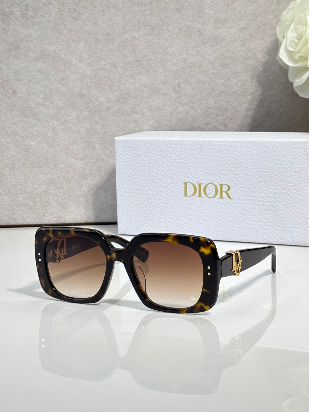 Dior sunglasses with tortoiseshell frames and brown gradient lenses, gold logo detail