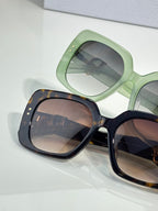 Two sunglasses: mint green frame with gray lenses and tortoiseshell frame with brown lenses