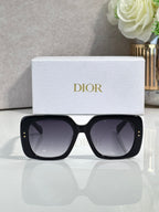 Black oversized sunglasses with gold stud details and gradient dark lenses.
