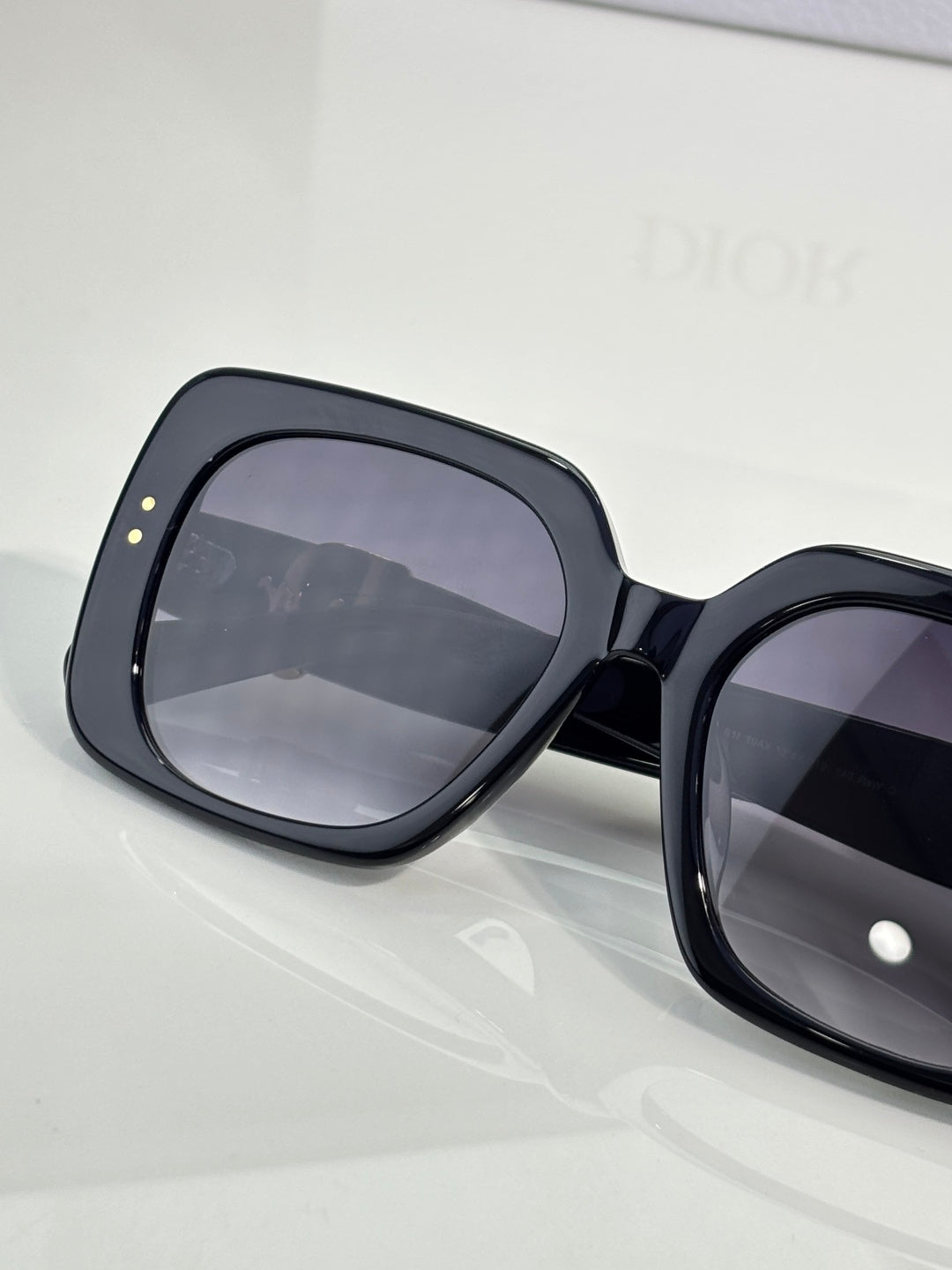 Black oversized sunglasses with dark gradient lenses and wide frame.