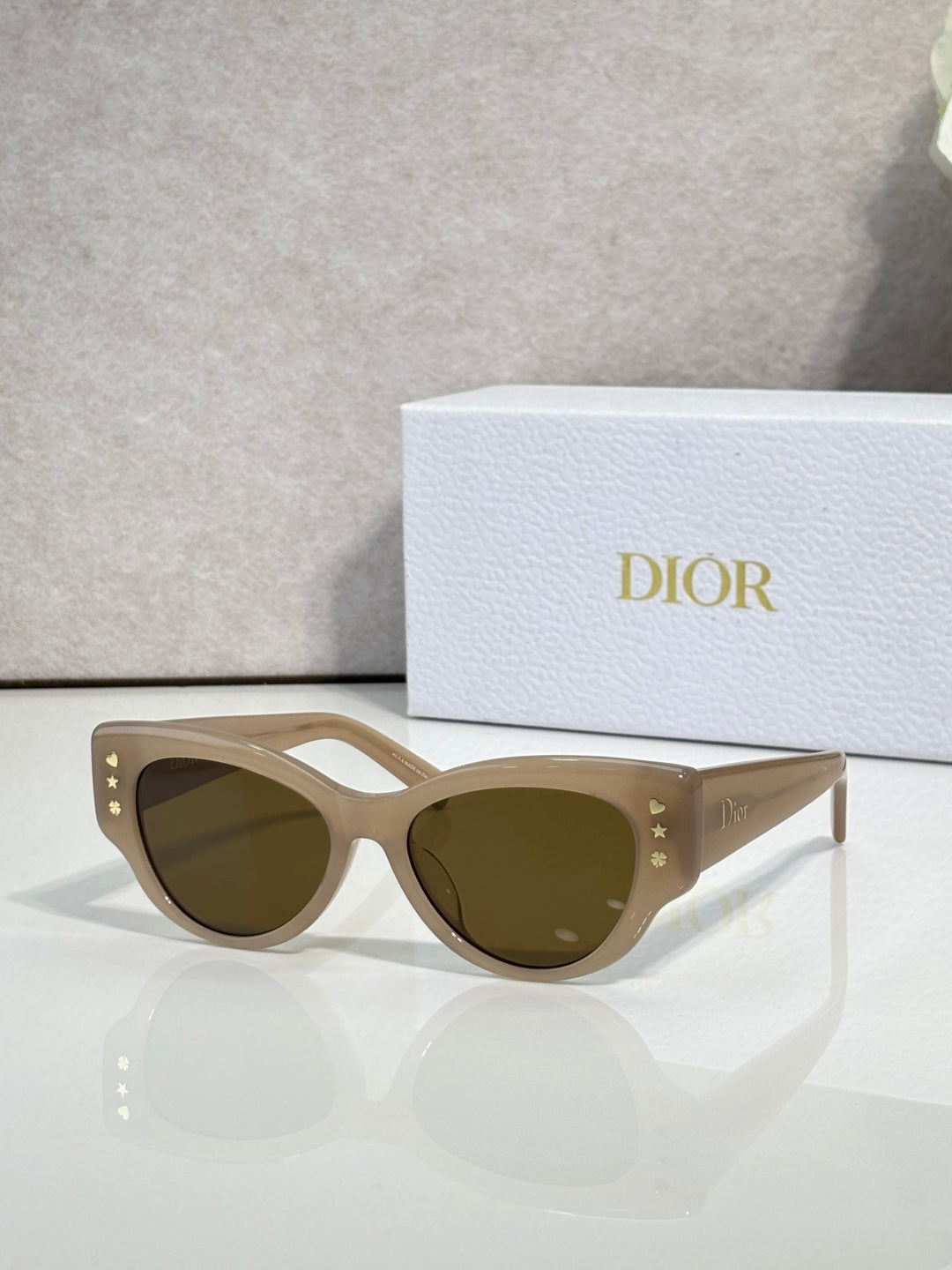 Dior cream cat-eye sunglasses with olive-brown lenses and star details