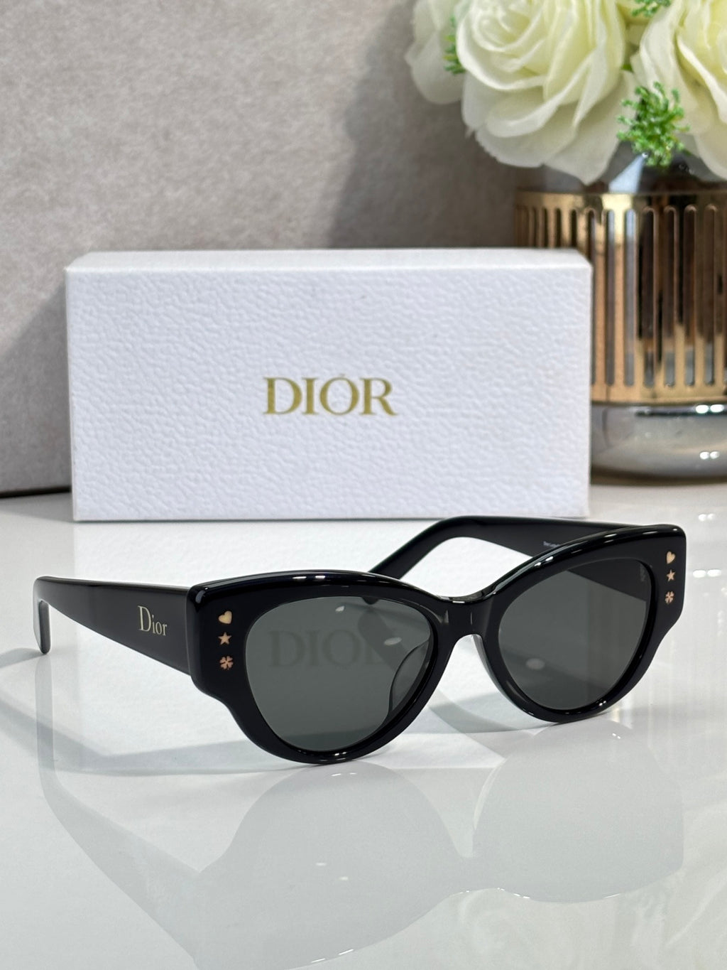 Dior black cat-eye sunglasses with dark lenses and gold logo details