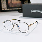 Round metal eyeglasses with clear lenses, dark frame, and gold-toned temple details