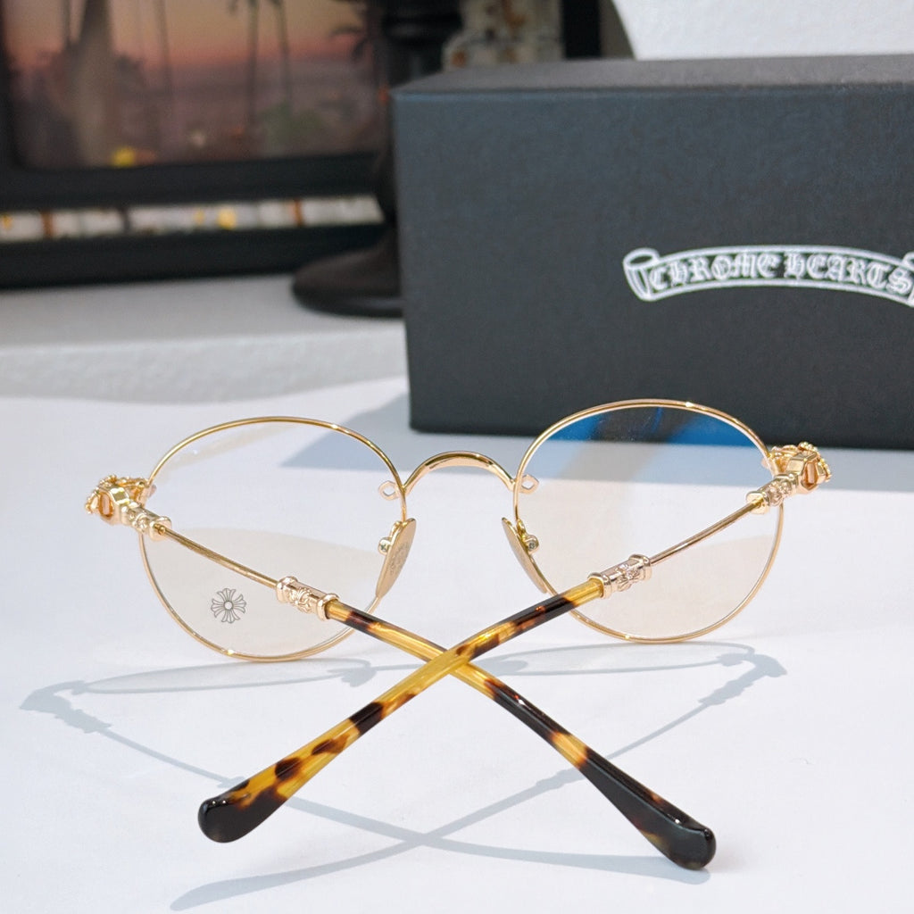 Round metal eyeglasses set with clear lenses, gold frame, and tortoise-pattern temples