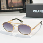 Gold-tone round sunglasses with violet tinted lenses and rhinestone chain temple detail