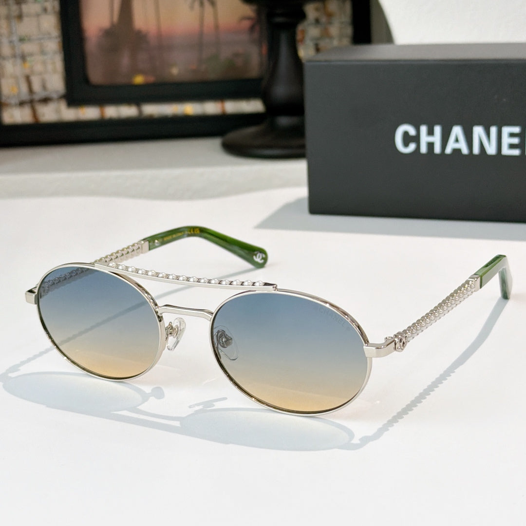 Silver-tone round sunglasses with light blue gradient lenses and rhinestone chain temple detail