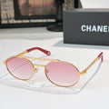 Gold-tone round sunglasses with pink tinted lenses and rhinestone chain accents