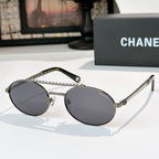 Silver-tone round sunglasses with dark gray tinted lenses and rhinestone chain temple detail
