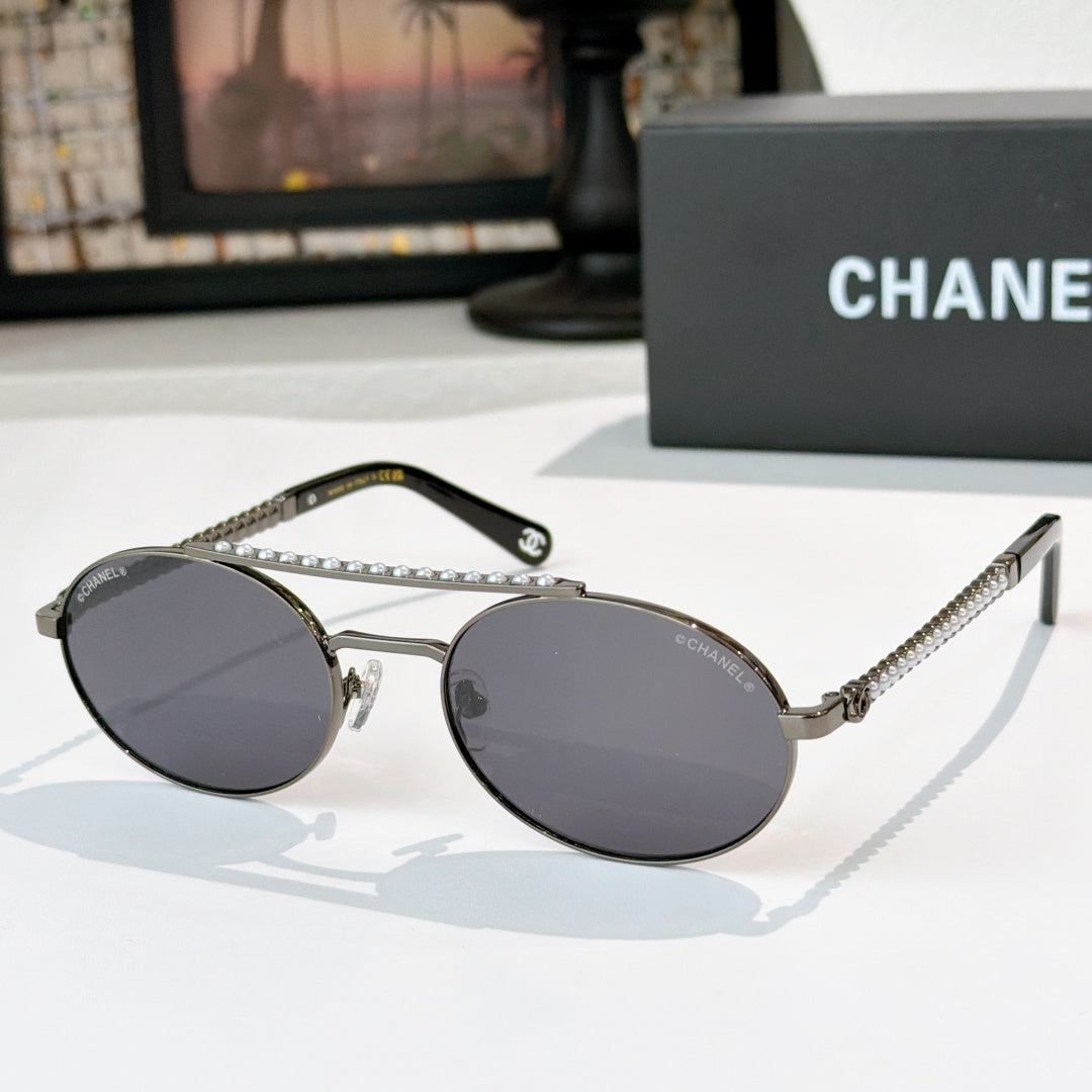 Silver-tone round sunglasses with dark gray tinted lenses and rhinestone chain temple detail