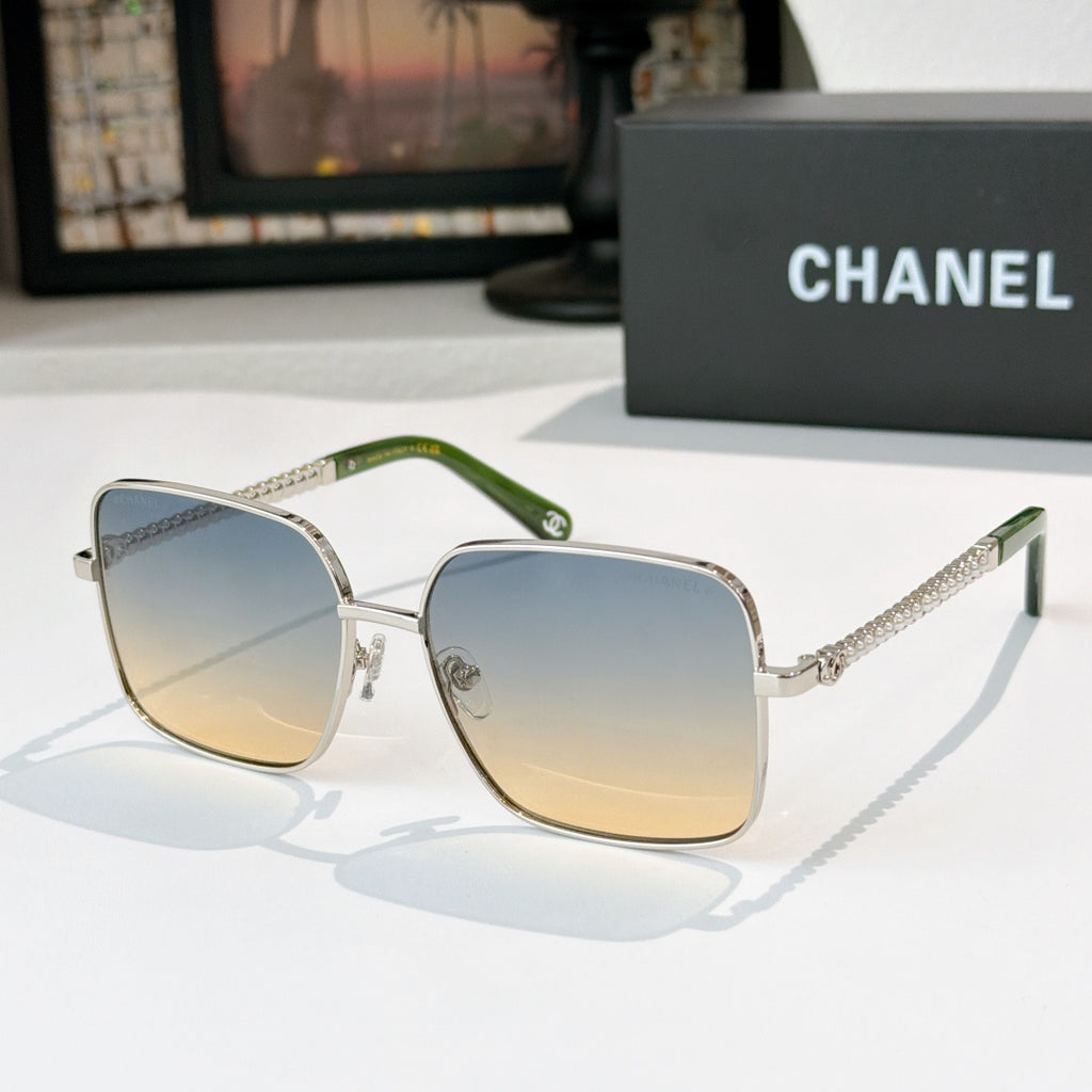 Chanel cat-eye sunglasses with silver-tone frame, green temples, and blue gradient lenses