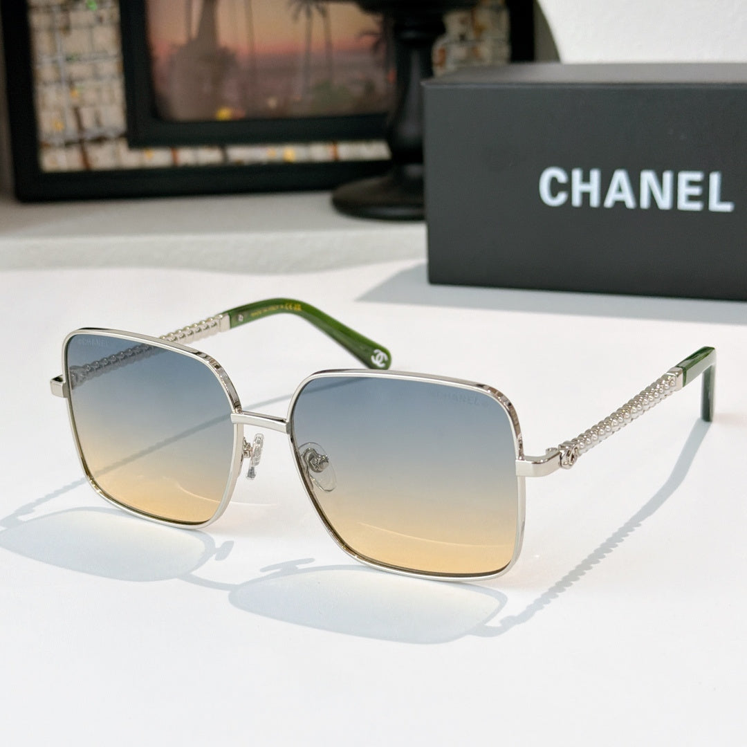 Chanel cat-eye sunglasses with silver-tone frame, green temples, and blue gradient lenses