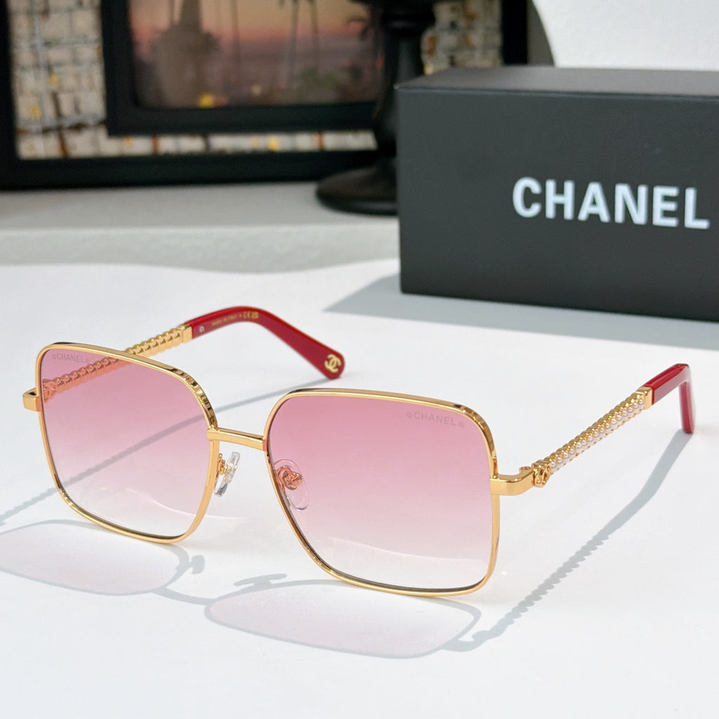 Chanel cat-eye sunglasses with gold-tone frame and pink gradient lenses, red accents
