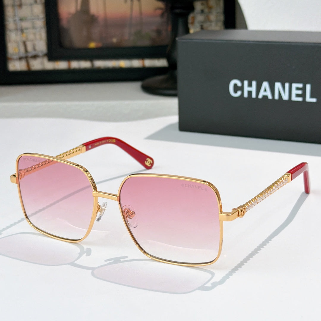 Chanel cat-eye sunglasses with gold-tone frame and pink gradient lenses, red accents