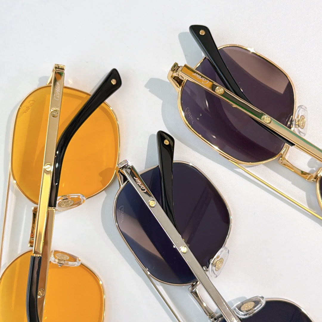 Sunglasses close-up with gold and black frames, featuring orange and purple tinted lenses