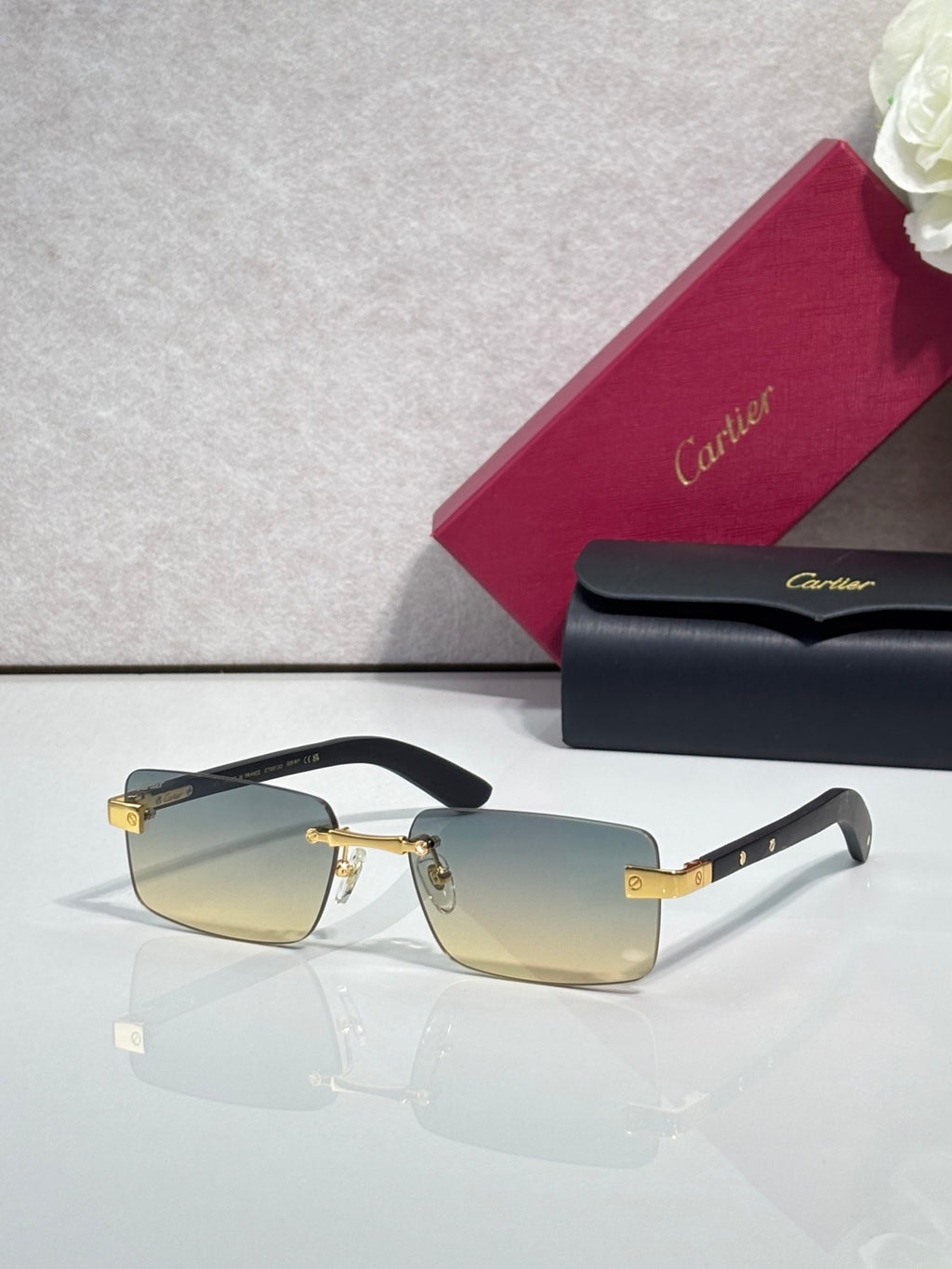 Cartier eyeglasses with black frame and gold-tone hinge, amber tinted lenses, rectangular shape