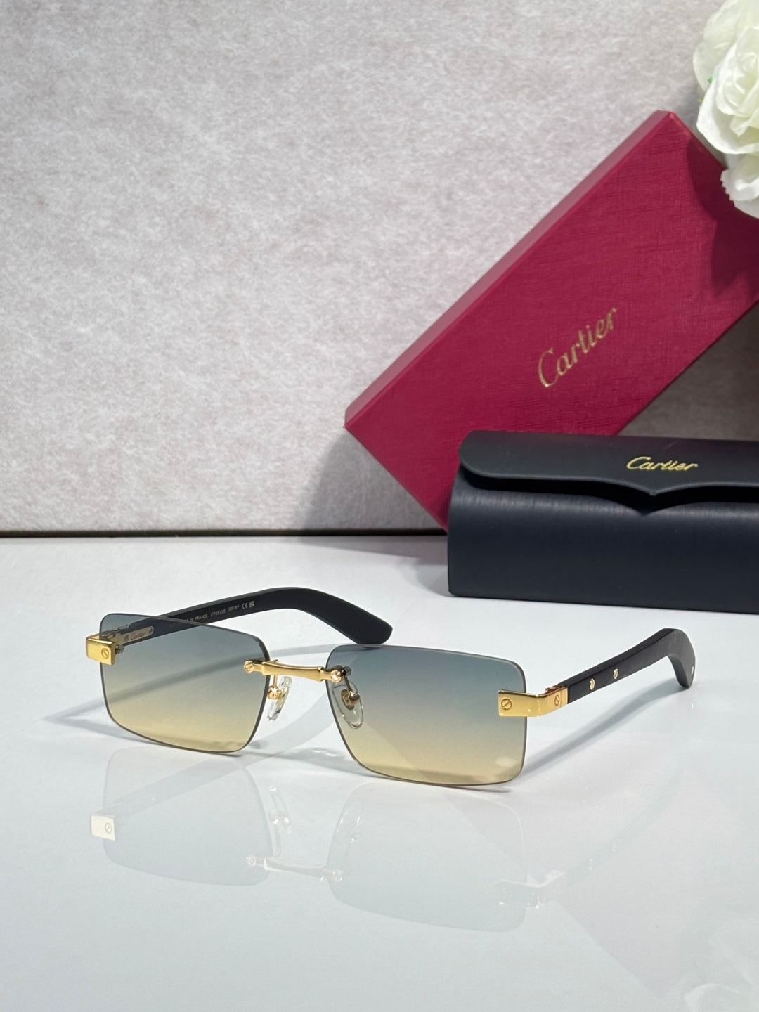 Cartier eyeglasses with black frame and gold-tone hinge, amber tinted lenses, rectangular shape