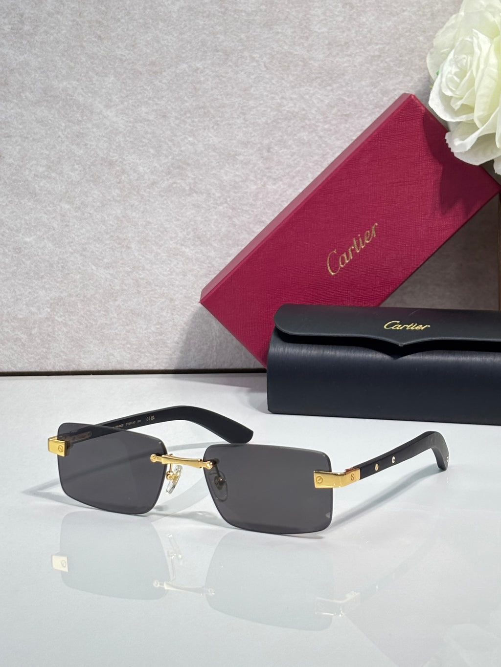Cartier eyeglasses with black frame and gold-tone hinge, dark lenses, rectangular shape