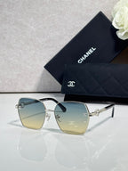 Square sunglasses with blue-to-yellow gradient lenses and gold-tone frames, with logo detail.