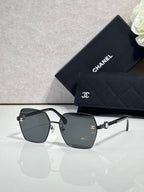 Square sunglasses with dark gray gradient lenses and silver-tone frames, with logo detail on temples.