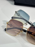 Stacked square sunglasses with blue and brown gradient lenses in metal frames.