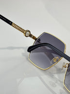 Chanel sunglasses close-up of black temple with gold chain trim and dark lenses