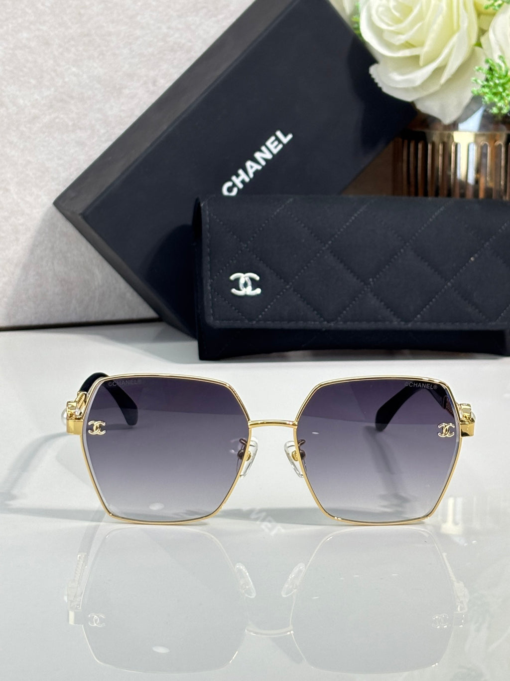 Chanel sunglasses with gold round-square frame and dark lenses, side arm hardware detail