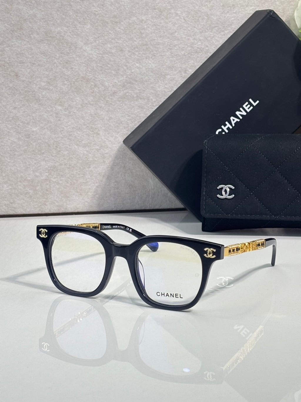 Navy blue square eyeglasses with gold CHANEL logo temple detail