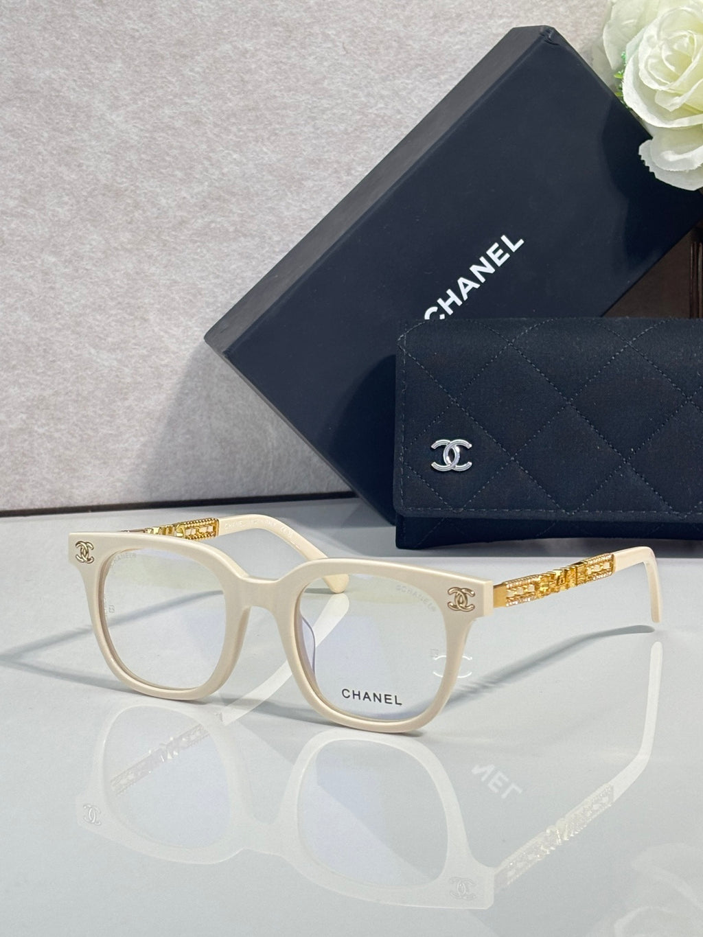 Cream and gold square eyeglasses with CHANEL logo temple detail