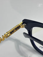 Black eyeglasses with gold chain temple detail