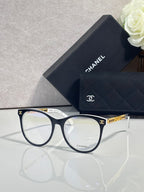 Chanel eyeglasses with dark blue frames and gold temple hardware, clear lenses