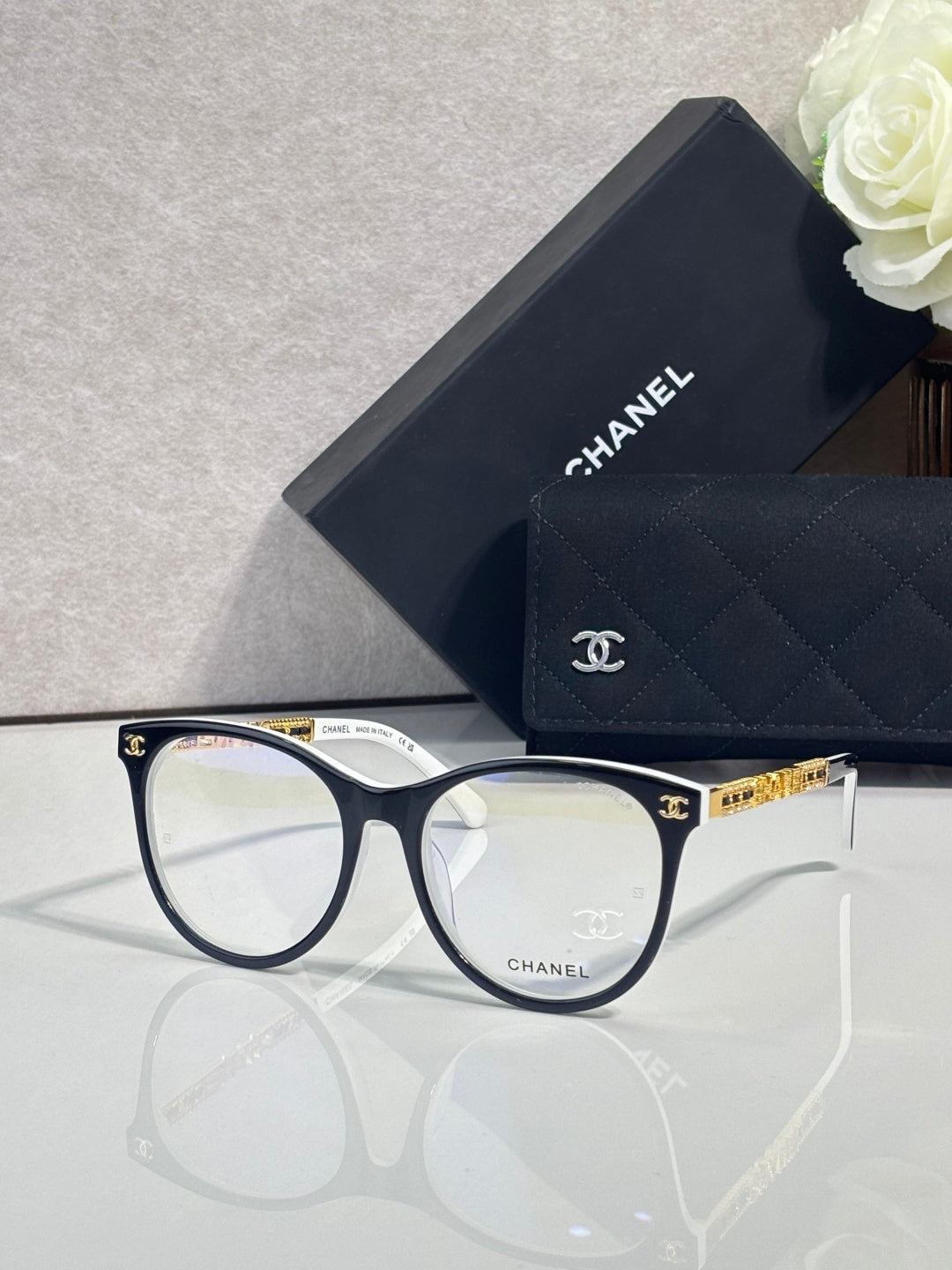 Chanel eyeglasses with dark blue frames and gold temple hardware, clear lenses