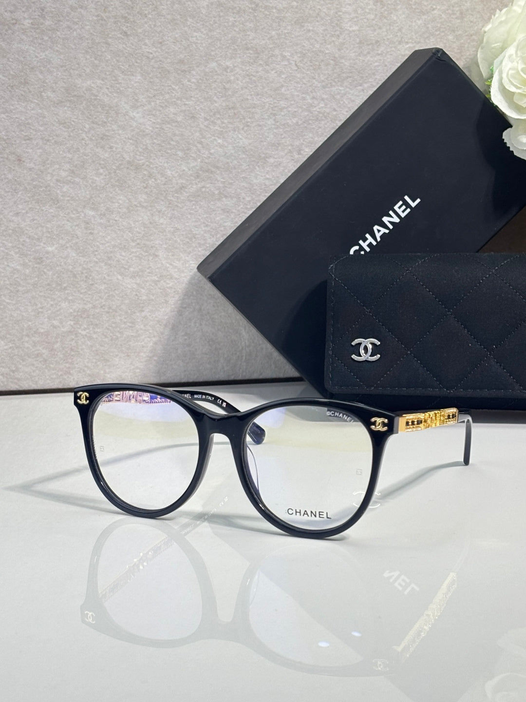 Chanel eyeglasses with dark blue frames and gold accents, clear lenses