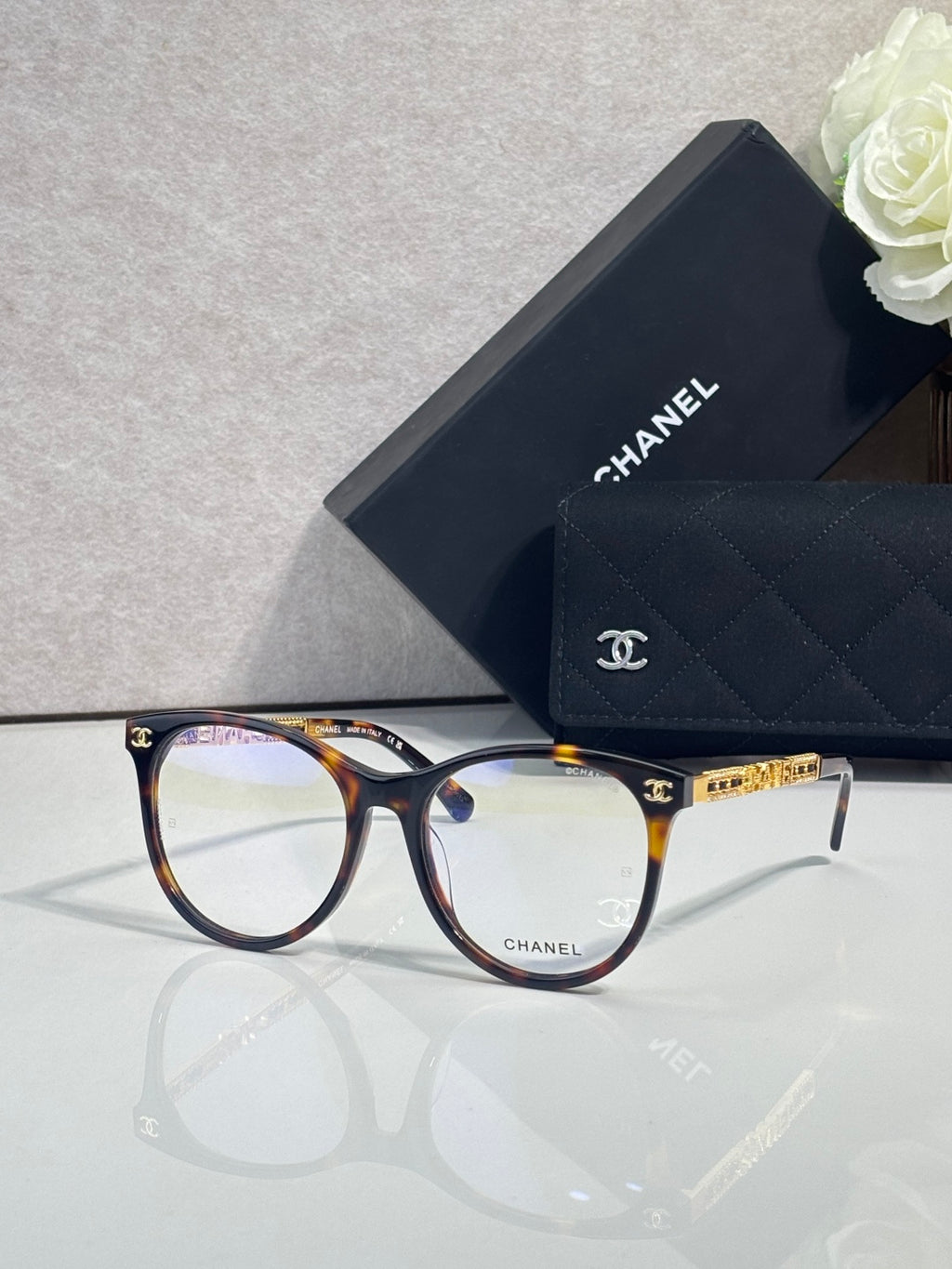 Chanel eyeglasses with tortoise-and-navy frames, gold bridge detail, clear lenses