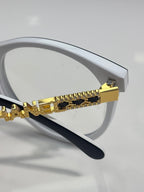 Chanel eyeglass frame with white arms and gold chain-style embellishment