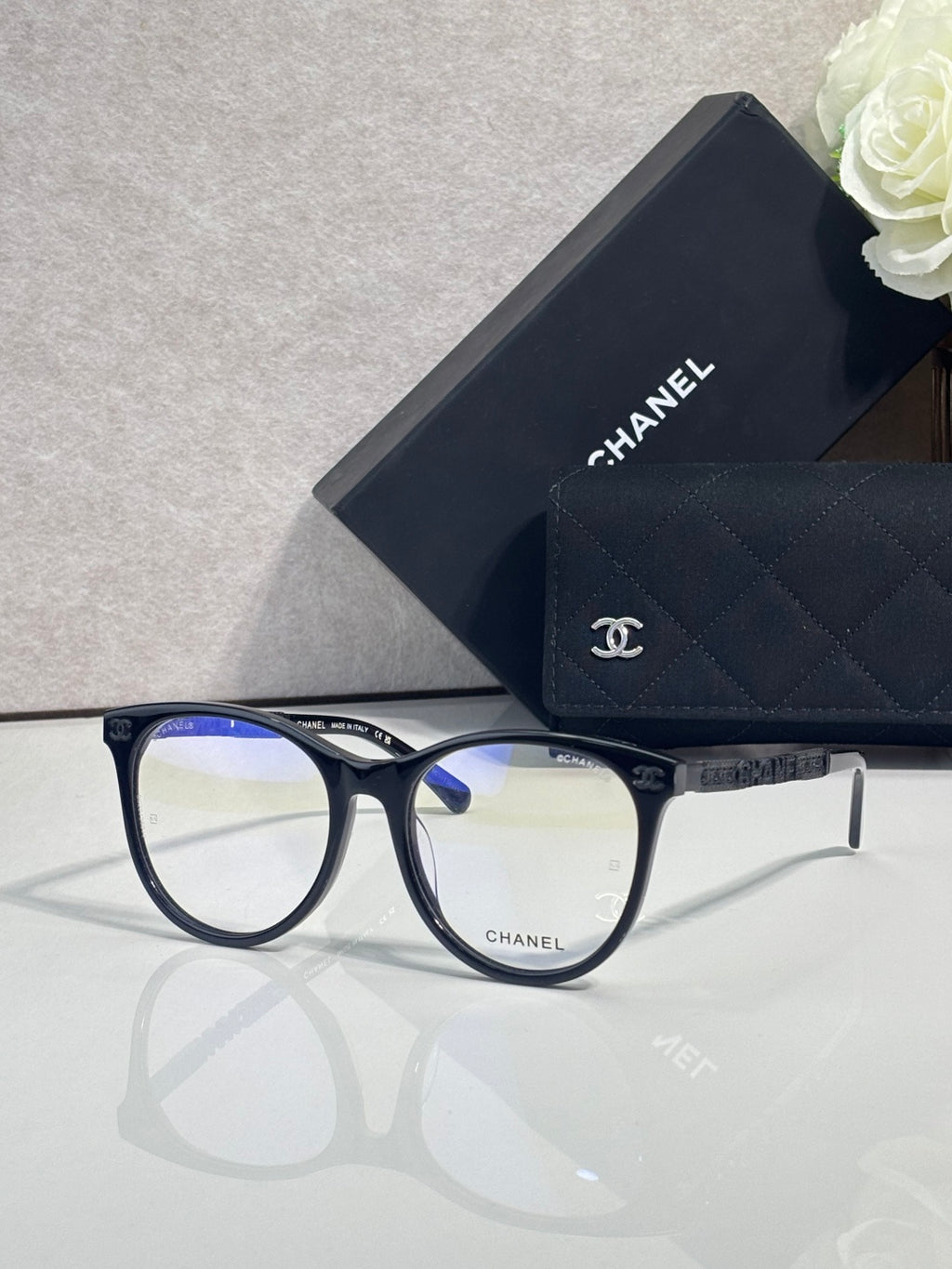 Chanel eyeglasses with dark blue frames, gold temple details, clear lenses