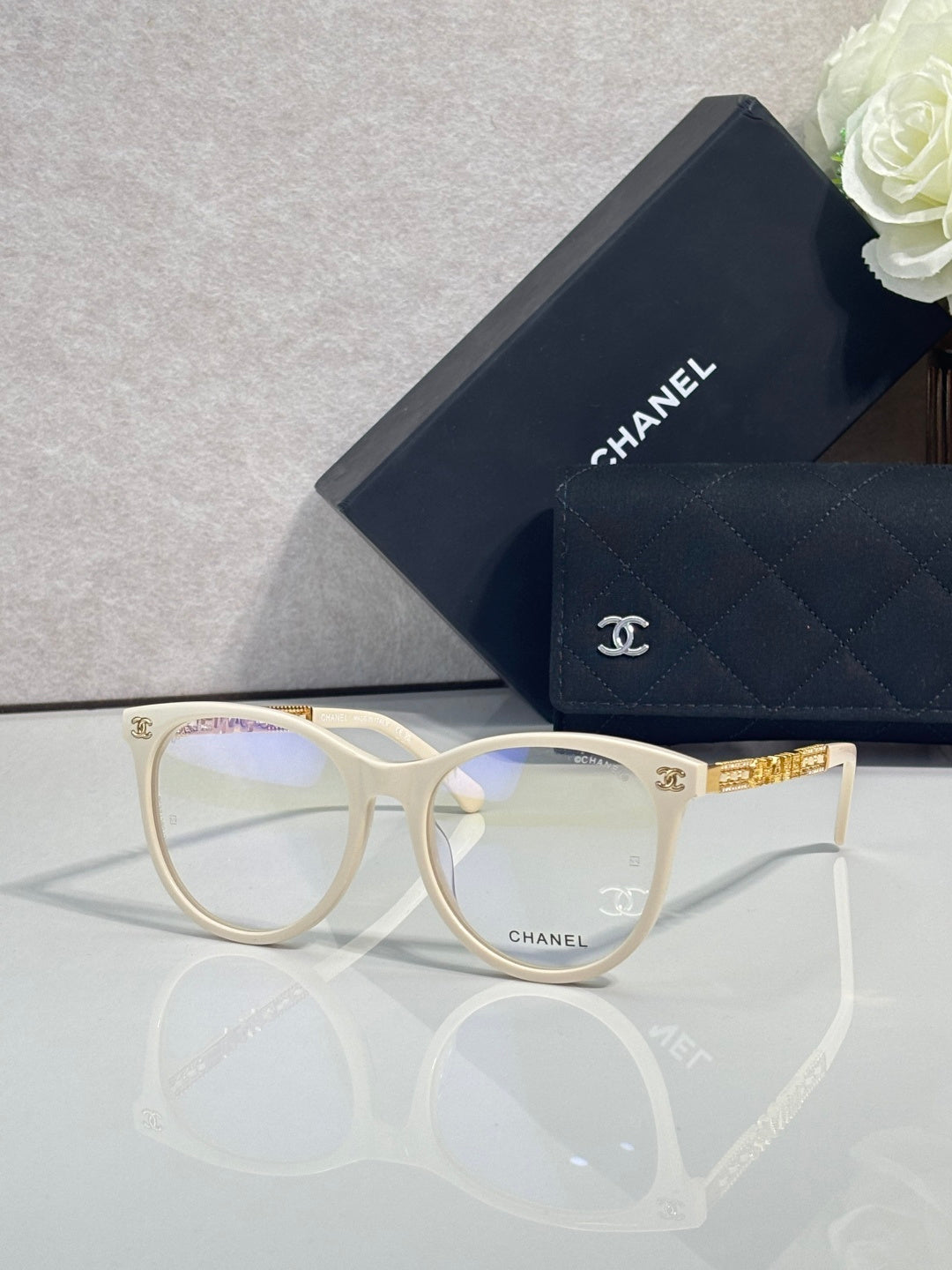 Chanel eyeglasses with cream frames, gold accents, and clear lenses